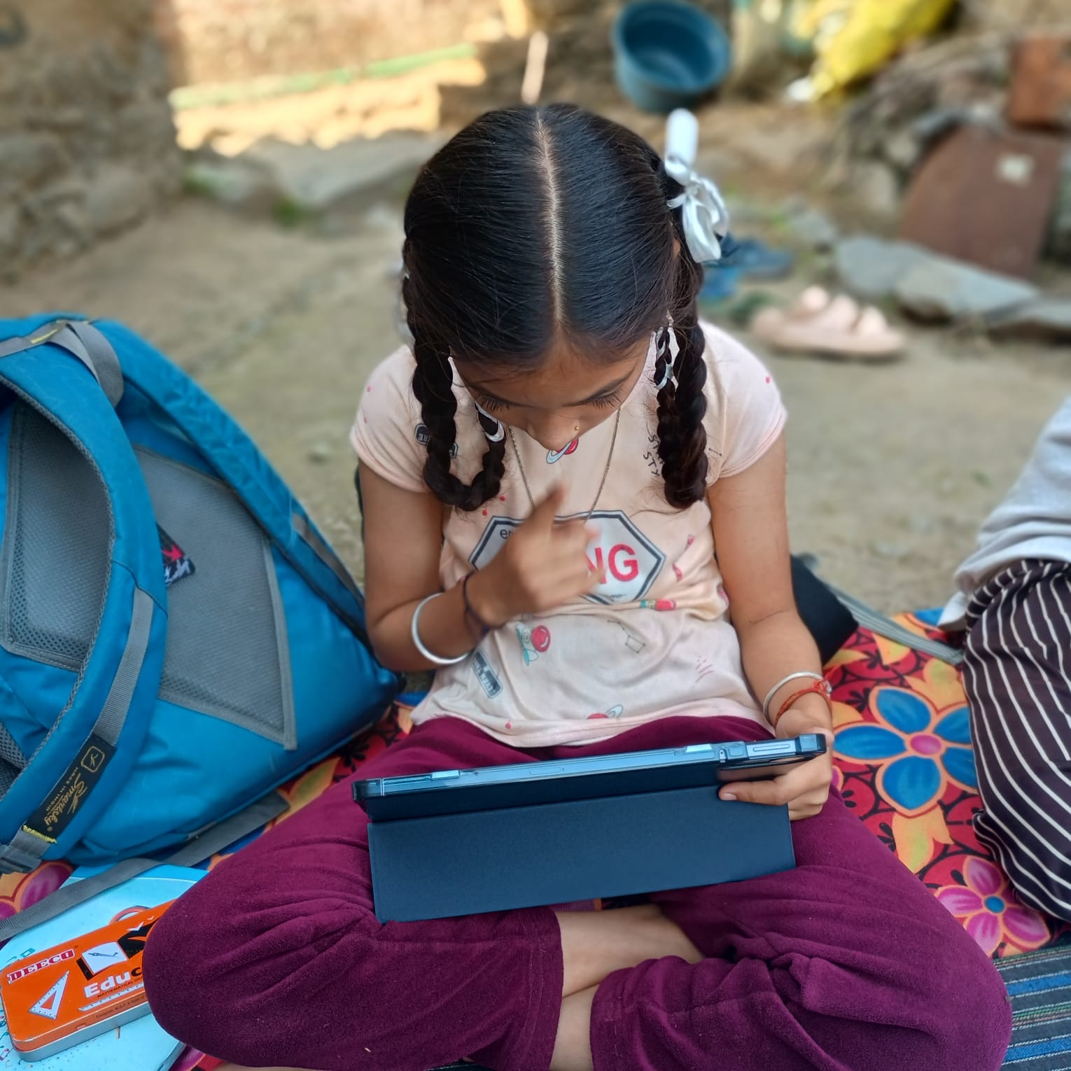 A child focused on a tablet during the CyberScout learning session